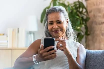 Woman smiling while using her phone